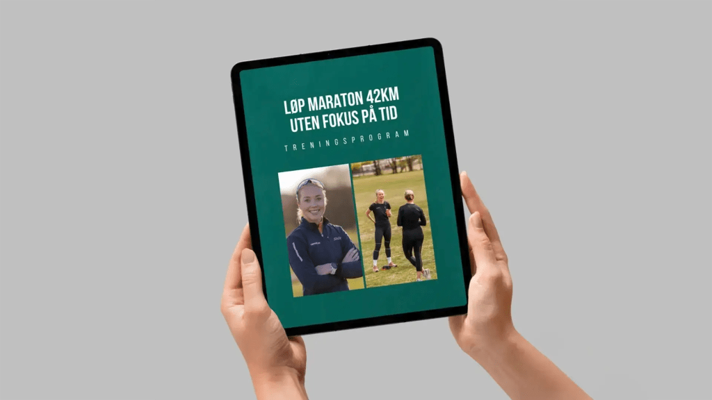Person holder et nettbrett med e-boken «Løp maraton 42 km uten fokus på tid – treningsprogram» på skjermen.